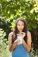Mixed race woman drinking lemonade outdoors