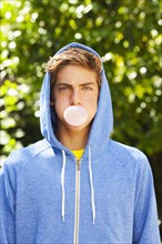 Caucasian teenager blowing bubble with gum