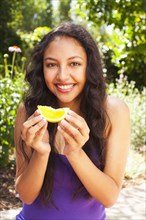 Mixed race teenager eating orange