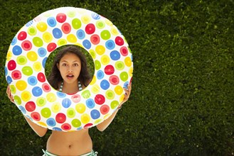 Mixed race girl holding inflatable ring