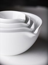 Close up of white nesting bowls with spouts