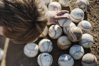 Caucasian boy choosing baseball on field