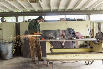 Artist grinding steel in workshop