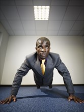 Black businessman doing push-ups