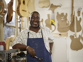 Black craftsman in guitar workshop