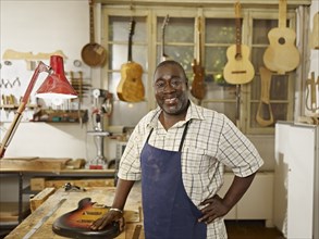 Black craftsman in guitar workshop