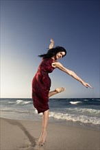 Hispanic woman dancing on beach