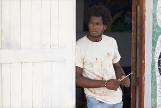 Black artist leaning in doorway