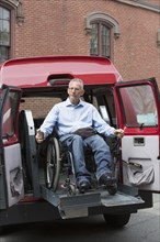 Caucasian man in wheelchair in accessible van