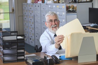 Caucasian businessman filing folders in office