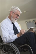 Caucasian businessman writing on notepad in office