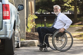 Caucasian businessman in wheelchair at van