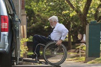 Caucasian businessman in wheelchair entering van