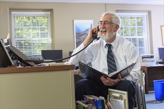 Caucasian businessman talking on phone at desk