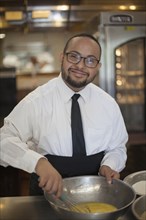 Mixed race chef with down syndrome cooking in restaurant