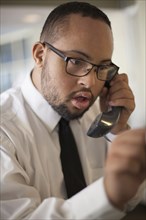 Mixed race man talking on telephone