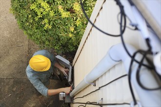 Caucasian worker installing cable box