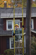 Caucasian worker climbing ladder