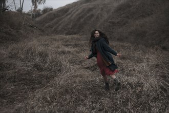 Caucasian woman running on grassy hill