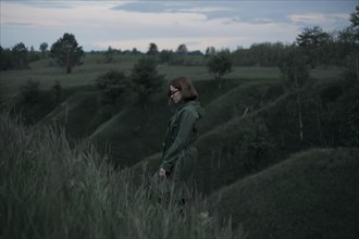 Pensive Caucasian woman standing on hill