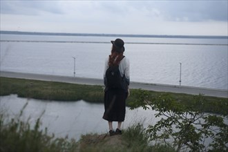 Caucasian woman standing on rock admiring ocean