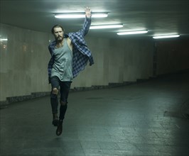 Carefree Caucasian man skipping in tunnel