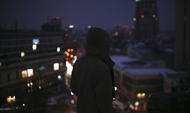 Silhouette of man on roof in city at night