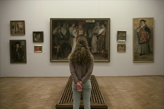 Caucasian teenage girl admiring paintings in museum