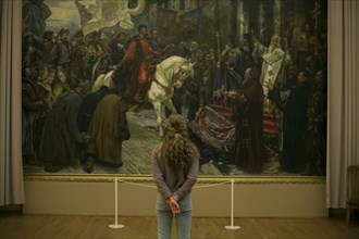 Caucasian teenage girl admiring painting in museum