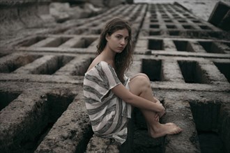 Portrait of Caucasian teenage girl sitting on structure