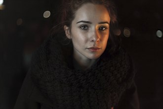 Portrait of serious Caucasian woman wearing scarf at night