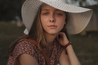 Portrait of serious Caucasian teenage girl wearing sun hat