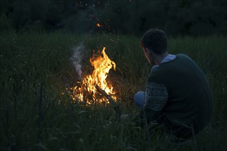 Caucasian man with campfire at night
