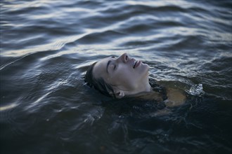 Caucasian woman floating in ocean with eyes closed