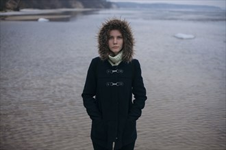 Caucasian woman wearing coat near ocean