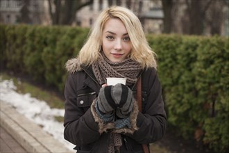 Caucasian woman warming hands on cup of coffee