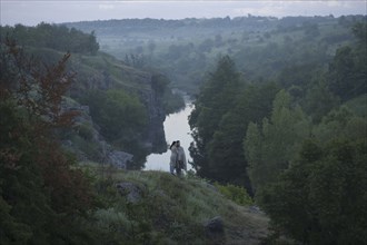 Caucasian couple standing on hill above river