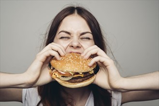Caucasian woman eating cheeseburger