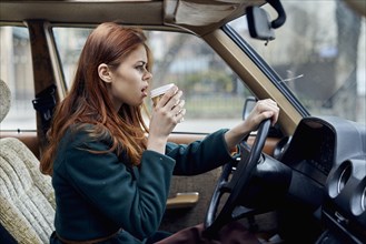Angry Caucasian woman driving car and drinking coffee