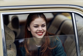 Caucasian woman smiling in back seat of car