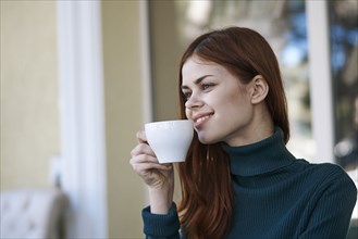 Caucasian woman smiling and drinking coffee