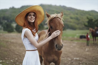 Smiling woman petting horse