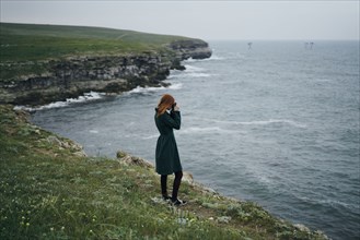 Caucasian woman photographing ocean