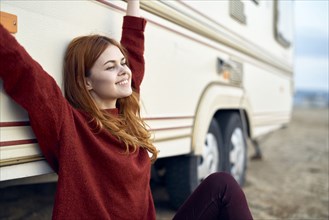 Caucasian woman stretching arms and leaning on motor home