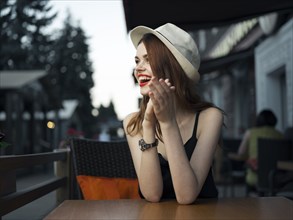 Caucasian woman at sidewalk cafe laughing