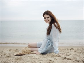 Smiling Caucasian woman sitting on beach