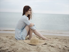Pensive Caucasian woman sitting on beach