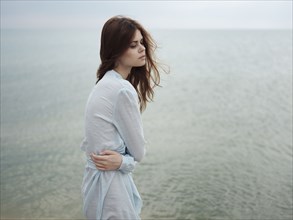 Troubled Caucasian woman standing near ocean