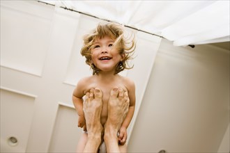 Portrait of girl balanced on father's feet