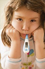 Portrait of girl with thermometer in mouth
